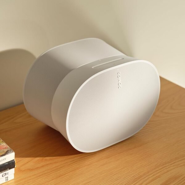 White Sonos speaker on a wooden table.