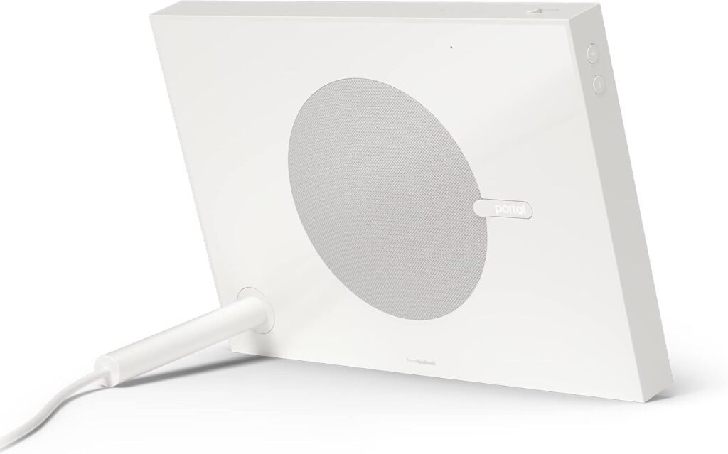 Back view of a white Facebook Portal smart display with a circular speaker grille and power cord attached.